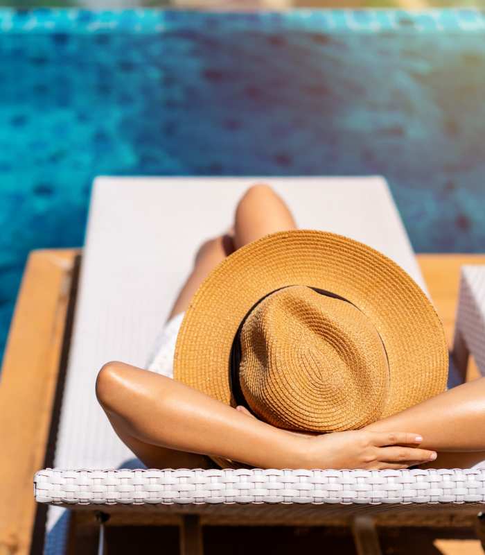 Resident laying in lounge chair near pool at Greer Mill Residences in Greer, South Carolina