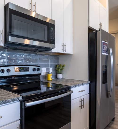 Modern kitchen with a stainless steel range at Charleston at Fannin Station in Houston, Texas