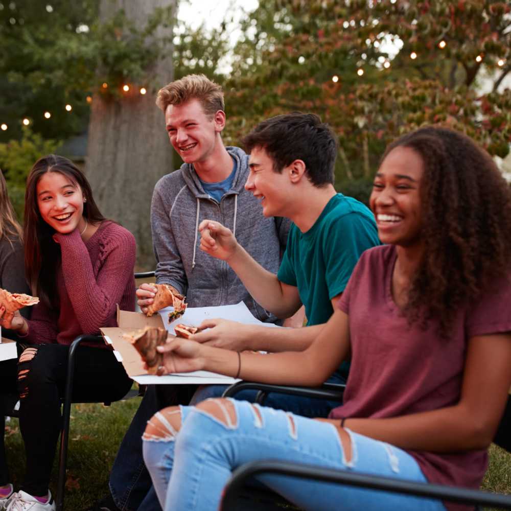 A couple of friends enjoying pizza in an open park at The Block at Sterling Heights in Sterling Heights, Michigan