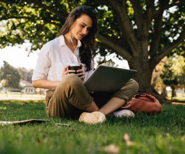 Woman working on her laptop in a park near Graham Residential in Miami Lakes, Florida