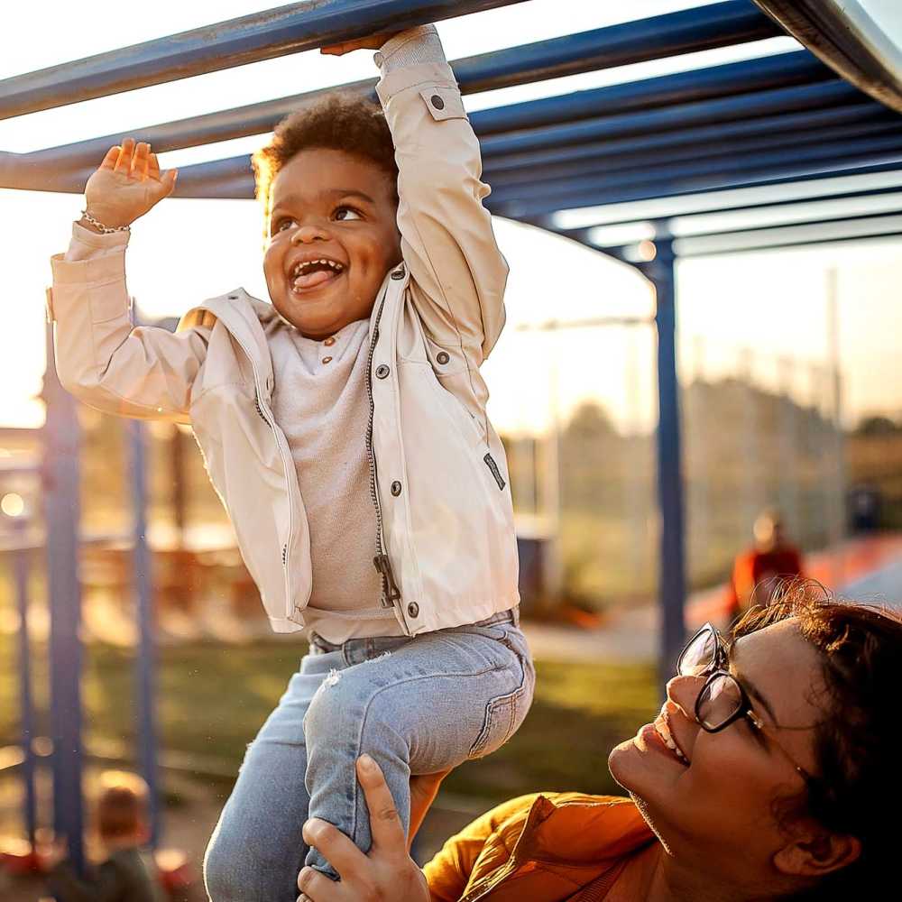 Child happily playing on a playground at Panorama at Arvada Ridge in Arvada, Colorado