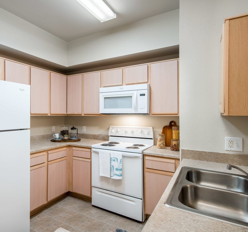 Large kitchen with a dual-basin sink and plenty of storage space in a model home at Rockbrook Creek in Lewisville, Texas