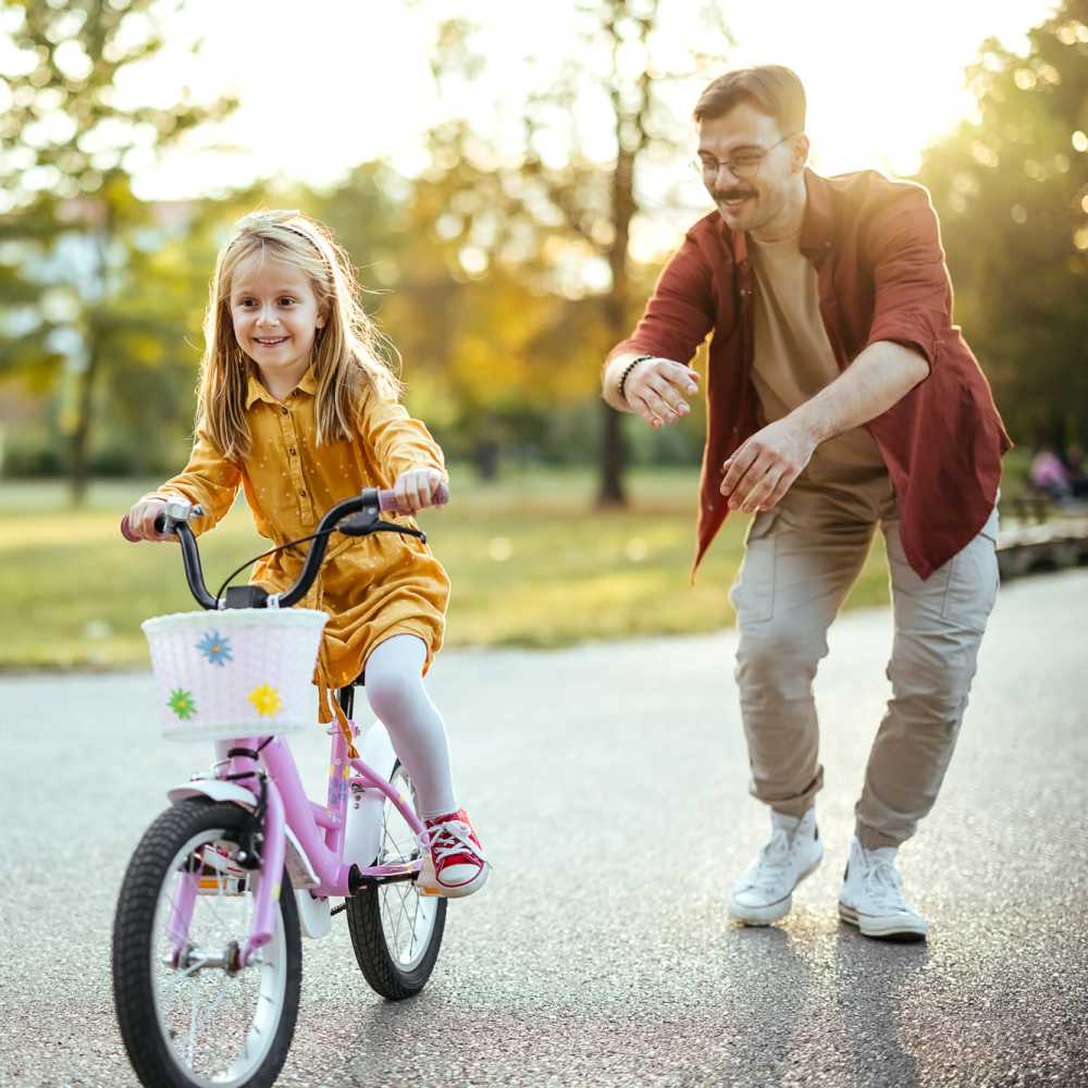 A father teaches her daughter to ride a bike in a park near Arlington Trace in Greenville, North Carolina