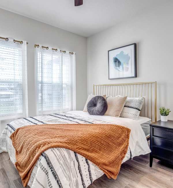 Bright bedroom with large windows and cozy decor at The Carlton At Lake Dexter in Winter Haven, Florida