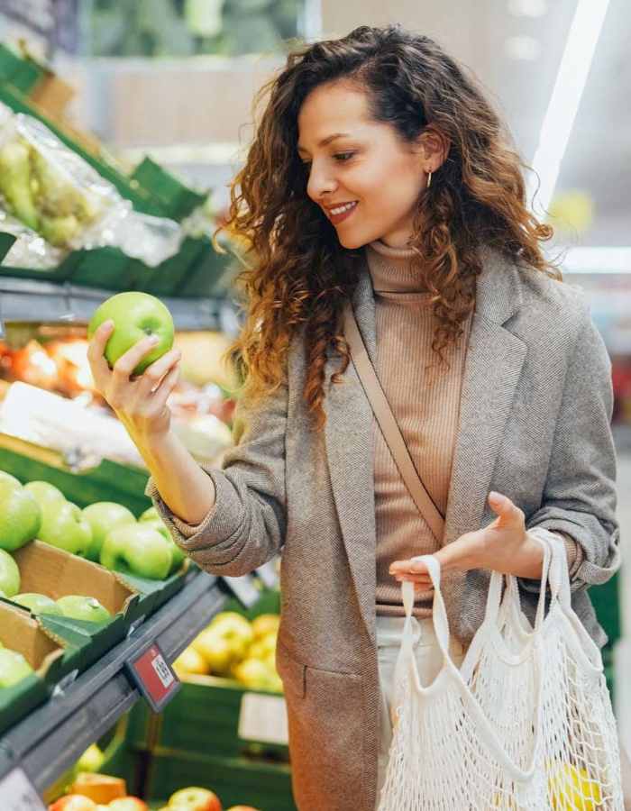 Woman shopping for apples at grocery store near 707 Leahy in Redwood City, California