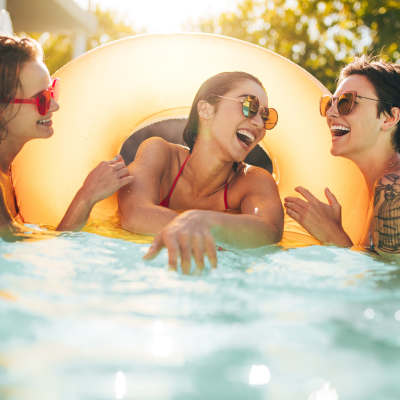 Resident friends in swimming pool at Bentley Green Apartment Homes, Jacksonville, Florida