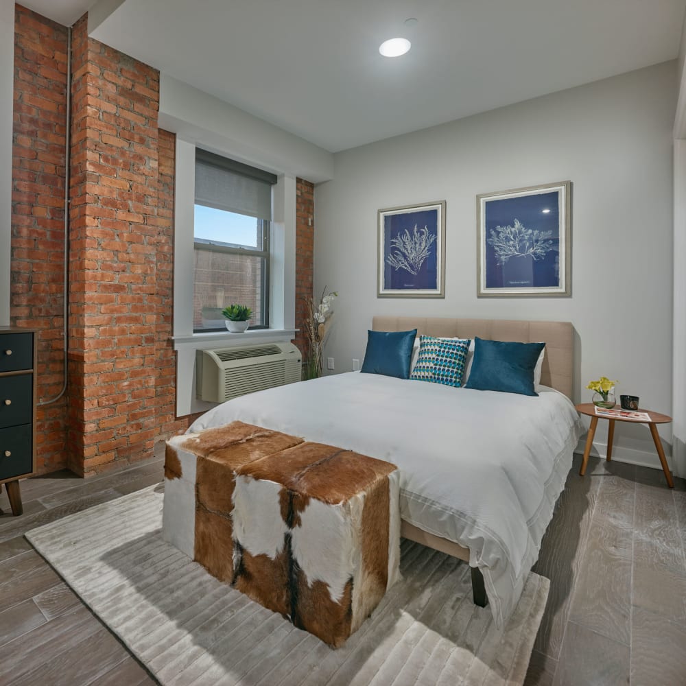 Bedroom with exposed brick and hardwood flooring at 210 Main in Hackensack, New Jersey