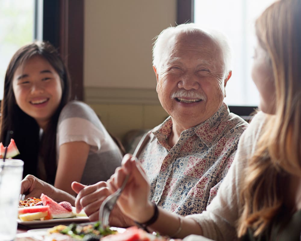 A resident smiling while eating at Waverly Place in Albany, Oregon