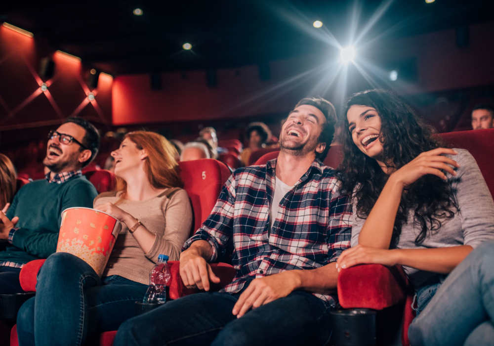 Friends watching movie in theater near Crystal Commons Townhomes in Gates, New York