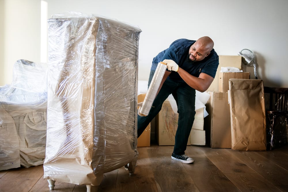Man wrapping furniture to move near A-American Self Storage in Hemet, California