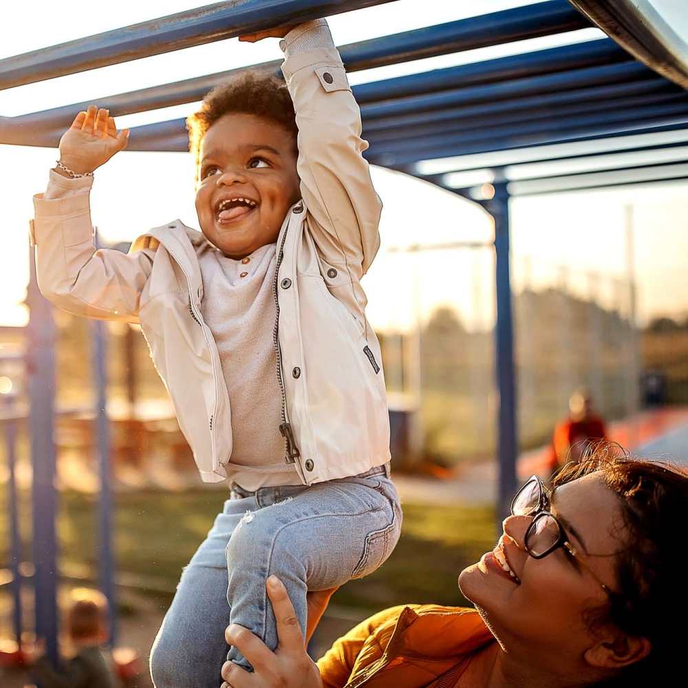 Child hanging from the monkey bars at the onsite children's playground at Belle Meade in Wilmington, North Carolina