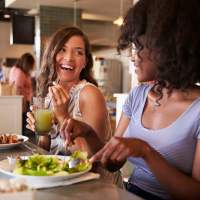 A couple of resident friends having food in a restaurant at Tapestry on Vaughn in Montgomery, Alabama,