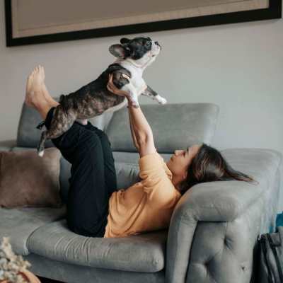 Resident playing with her dog on the couch in the living room at Westmont Village in Charlotte, North Carolina