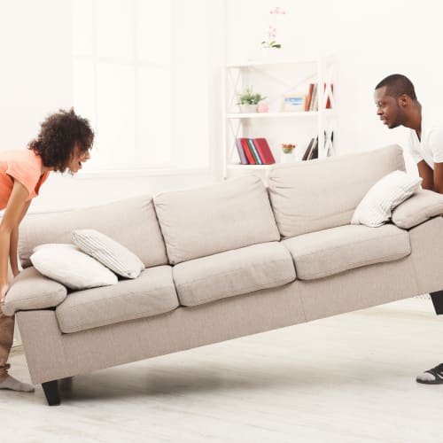 Residents lifting a couch in a home at Adobe Flats IV in Twentynine Palms, California