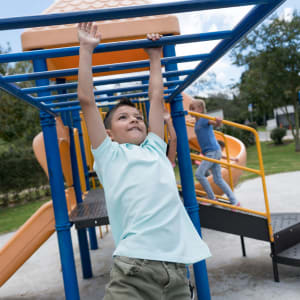 Young resident playing on the playground at Willow Glen in Fort Worth, Texas