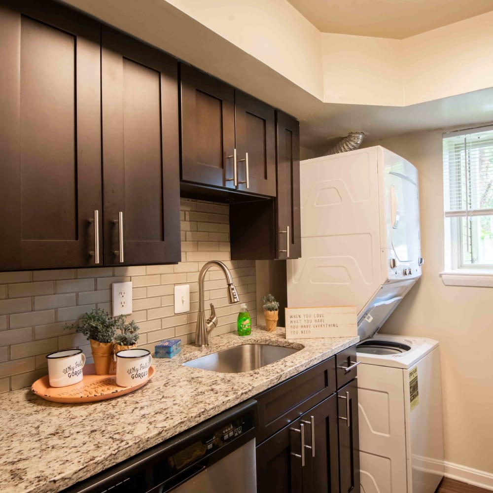 Kitchen with espresso cabinets, granite countertops, and in-unit stacked laundry at Glen Ridge Apartment Homes in Glen Burnie, Maryland