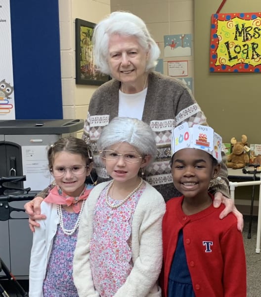 Peggy Holly pictured with three kindergarten children dressed as senior adults