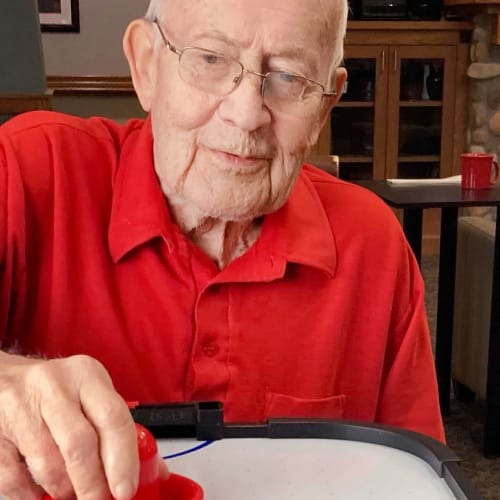 Resident playing air hockey at Glen Carr House Memory Care in Derby, Kansas