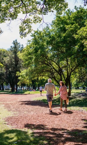 Residents taking a walk through a park near Franciscan Apartments in Garland, Texas