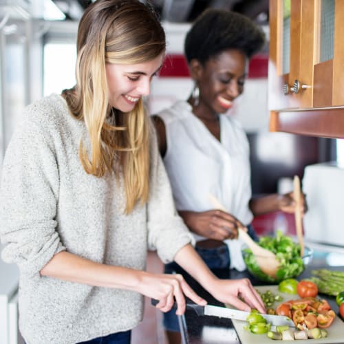 Happy residents are cooking in the kitchen at Bard Estates in Port Hueneme, California