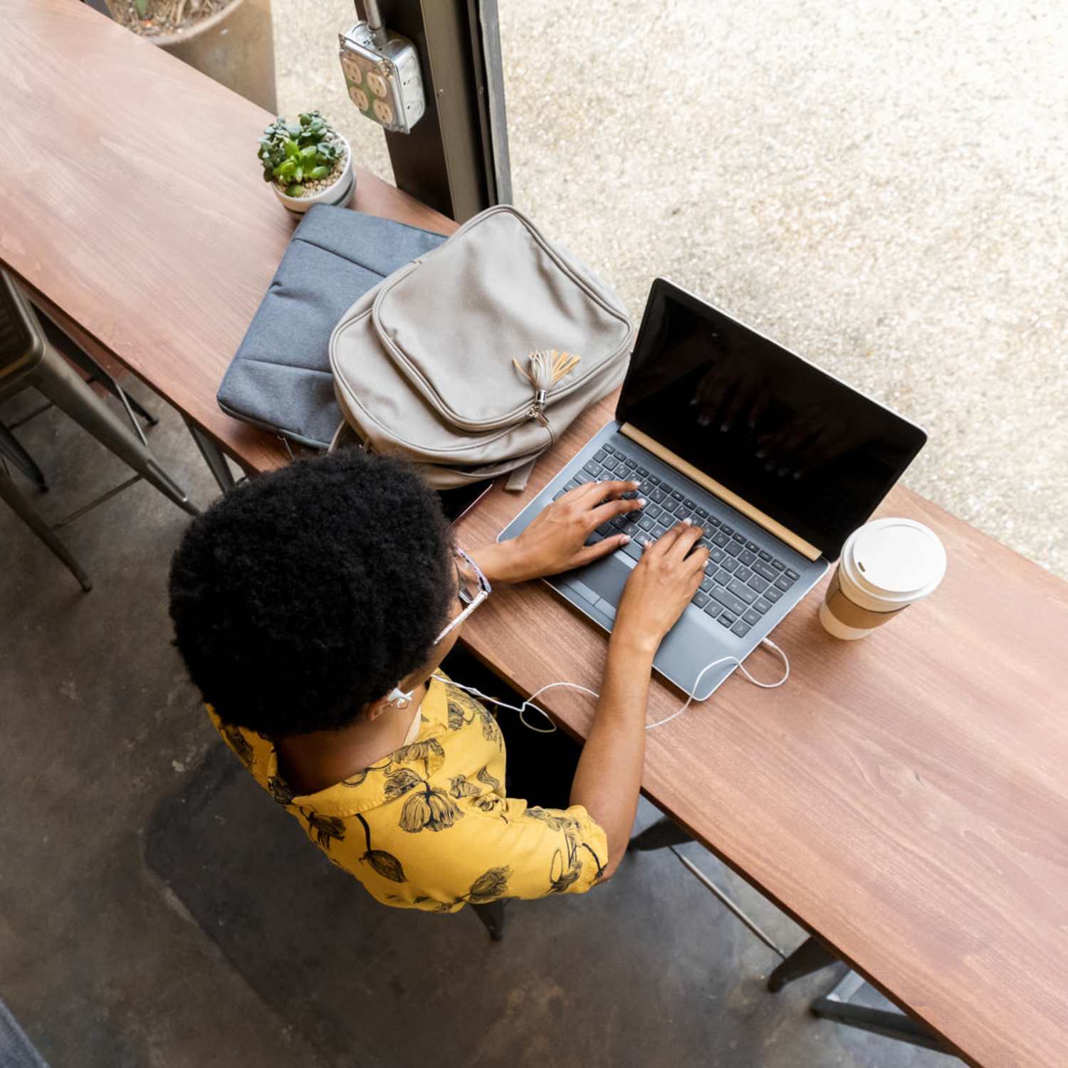 Resident at coffee shop on laptop at The Quarters at Stillwater in Stillwater, Oklahoma