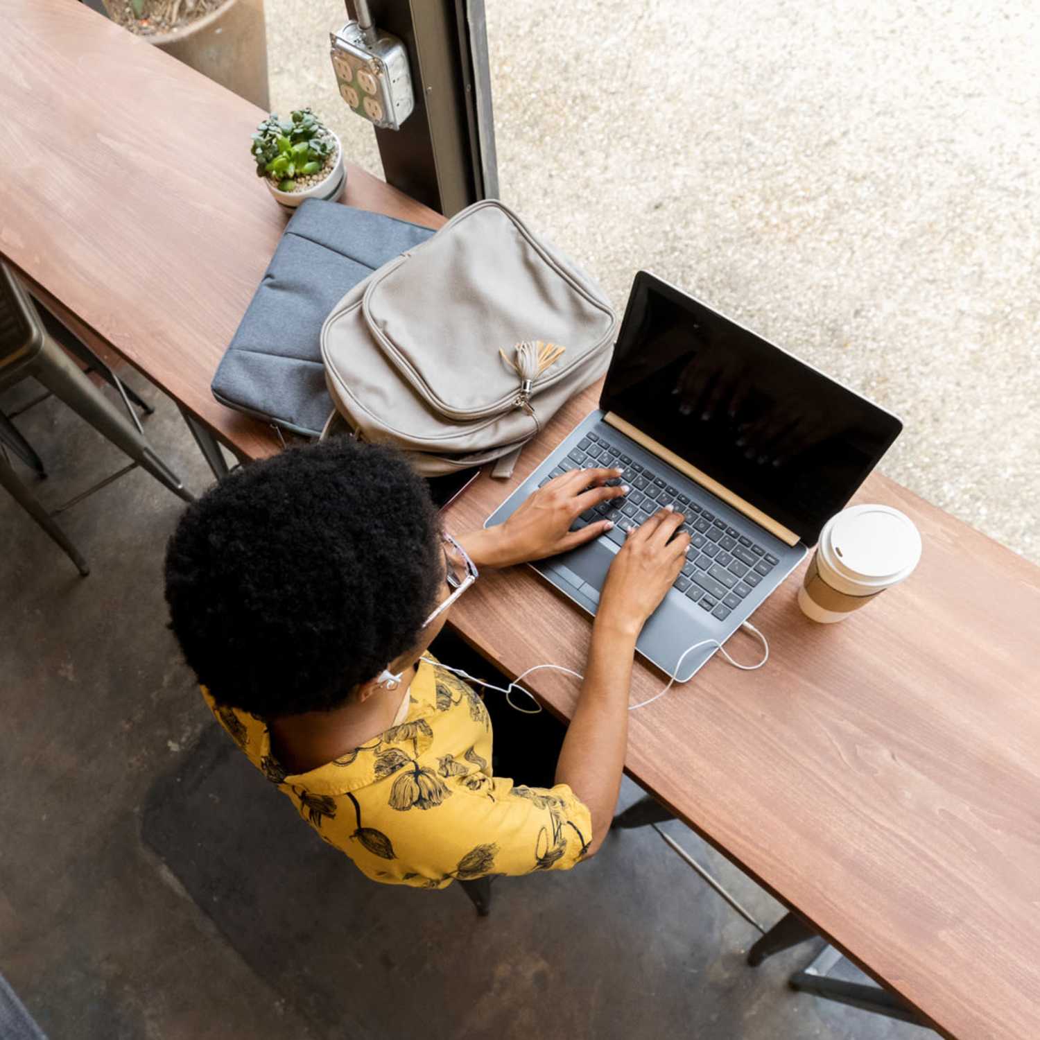 Resident at coffee shop on laptop at The Quarters at Bloomington in Bloomington, Indiana