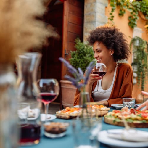 Resident and friends catching up over wine and dinner on the patio of a favorite local eatery near Solaire 8200 Dixon in Silver Spring, Maryland