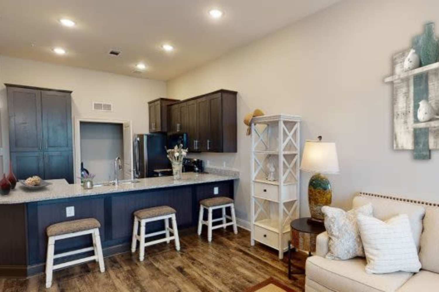 Modern furnishings and hardwood-style flooring in a model home's living space at Erdace Apartments in Lake Charles, Louisiana