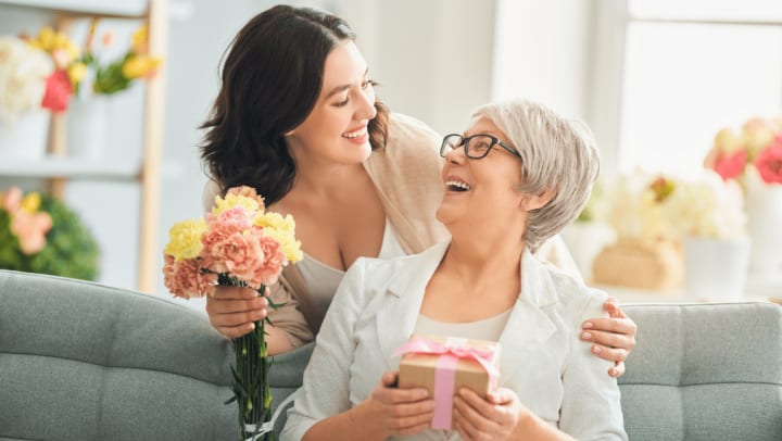 a senior woman laughing after receiving a gift