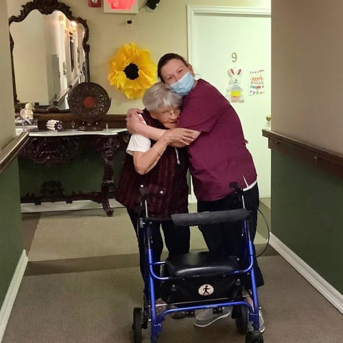 Masked caretaker with a resident at Canoe Brook Assisted Living in Duncan, Oklahoma
