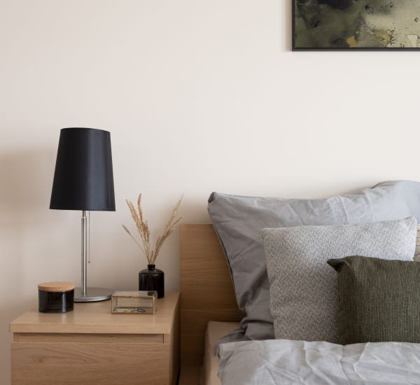 A furnished bedroom with a well-made bed, side table and lamp at EOS in Orlando, Florida EOS in Orlando, Florida