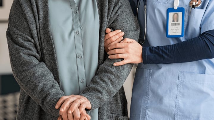 Therapist helping senior woman walk