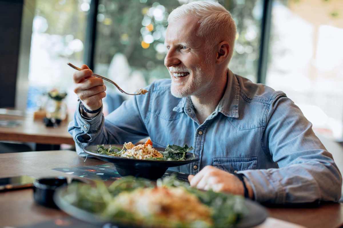 Elderly resident eating food at Traditions at Colorado Springs in Colorado Springs, Colorado