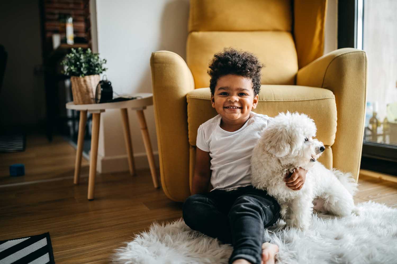 A child with his furry friend posing for a picture in living room at South Oak Villas in Garrett, Indiana