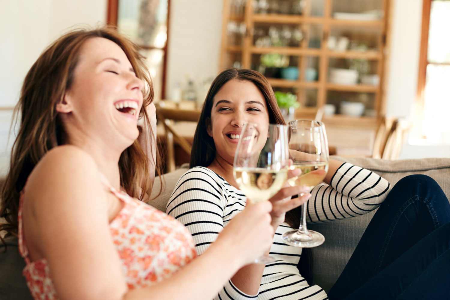 Residents enjoying drinks in their cozy living room at Sable Pointe Apartments in Hart, Michigan