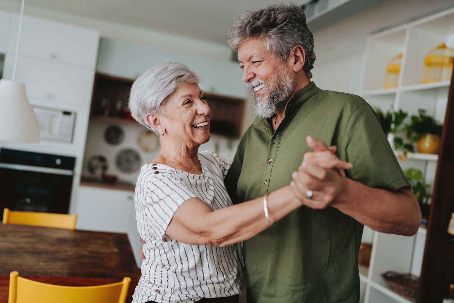 Resident couple dancing in their living room at Rolling Brook Apartments in Algonac, Michigan