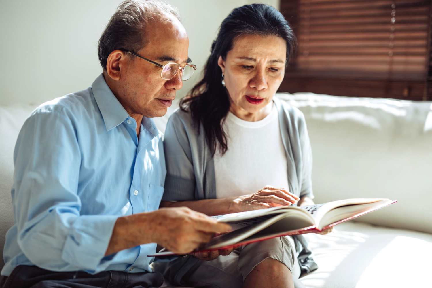Resident couple reading a book at Whispering Pines in Grayling, Michigan
