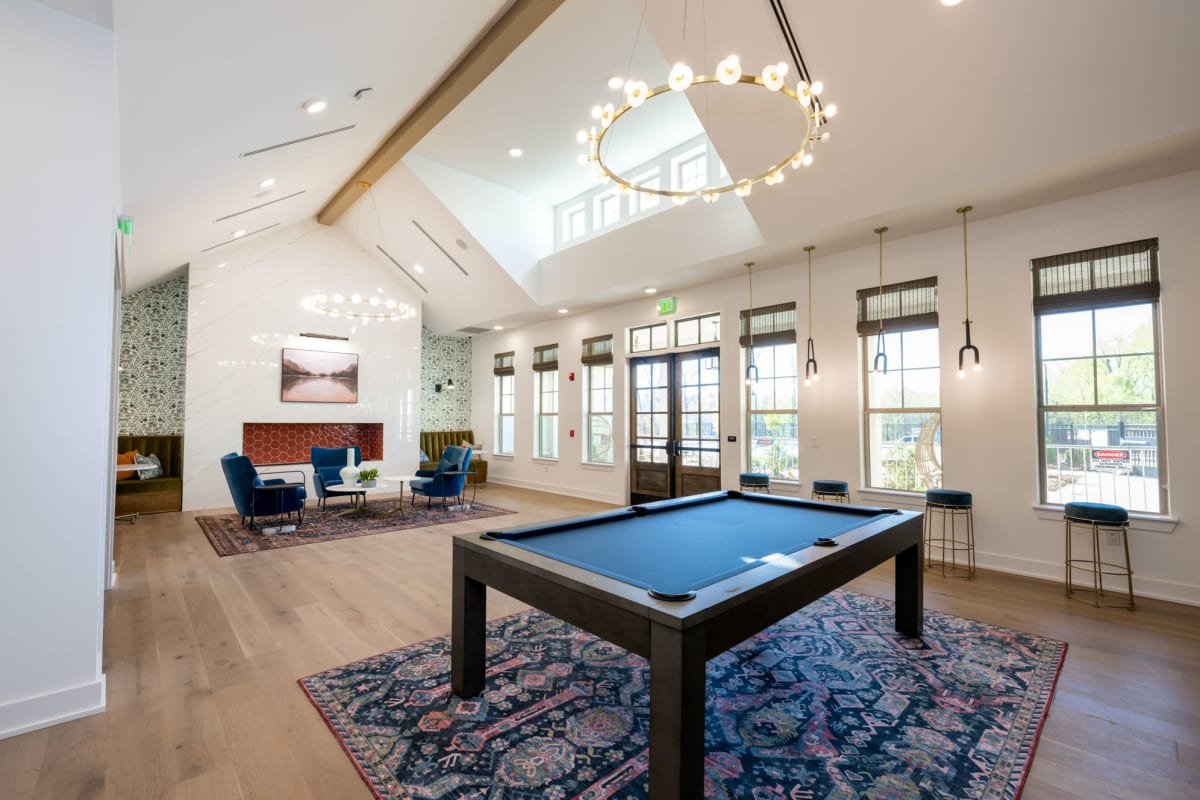 Indoor community area with pool table and chandelier 