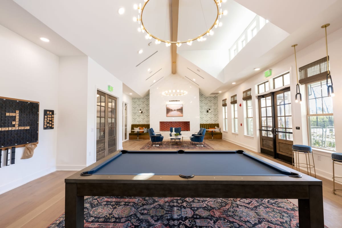 Indoor community area with pool table and chandelier 