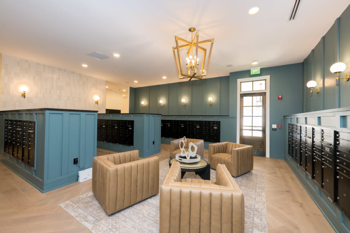 Indoor mail room with black mailboxes and sitting area