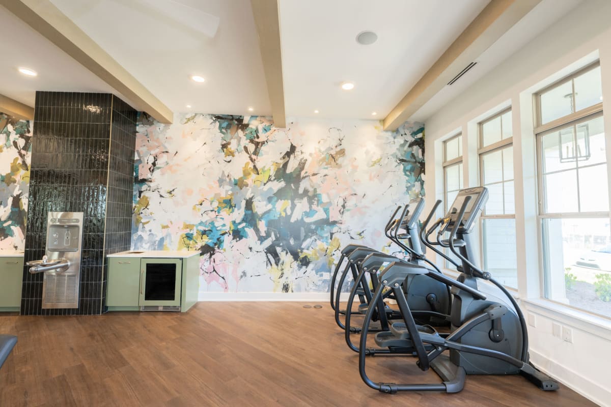 Indoor fitness area with windows and ellipticals with water fountain 