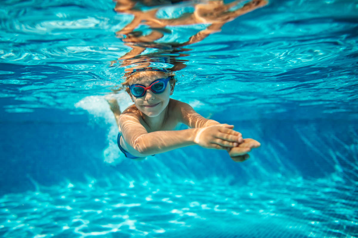 Kid swimming and enjoying in community pool at Republic House at Frisco Bridges in Frisco, Texas