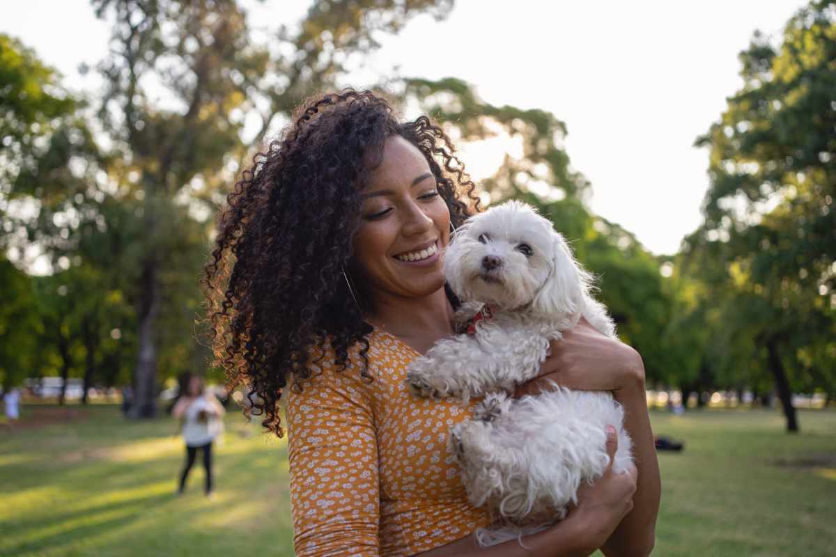 Happy resident playing with pet dog in bark park at Bandera Ranch in Euless, Texas