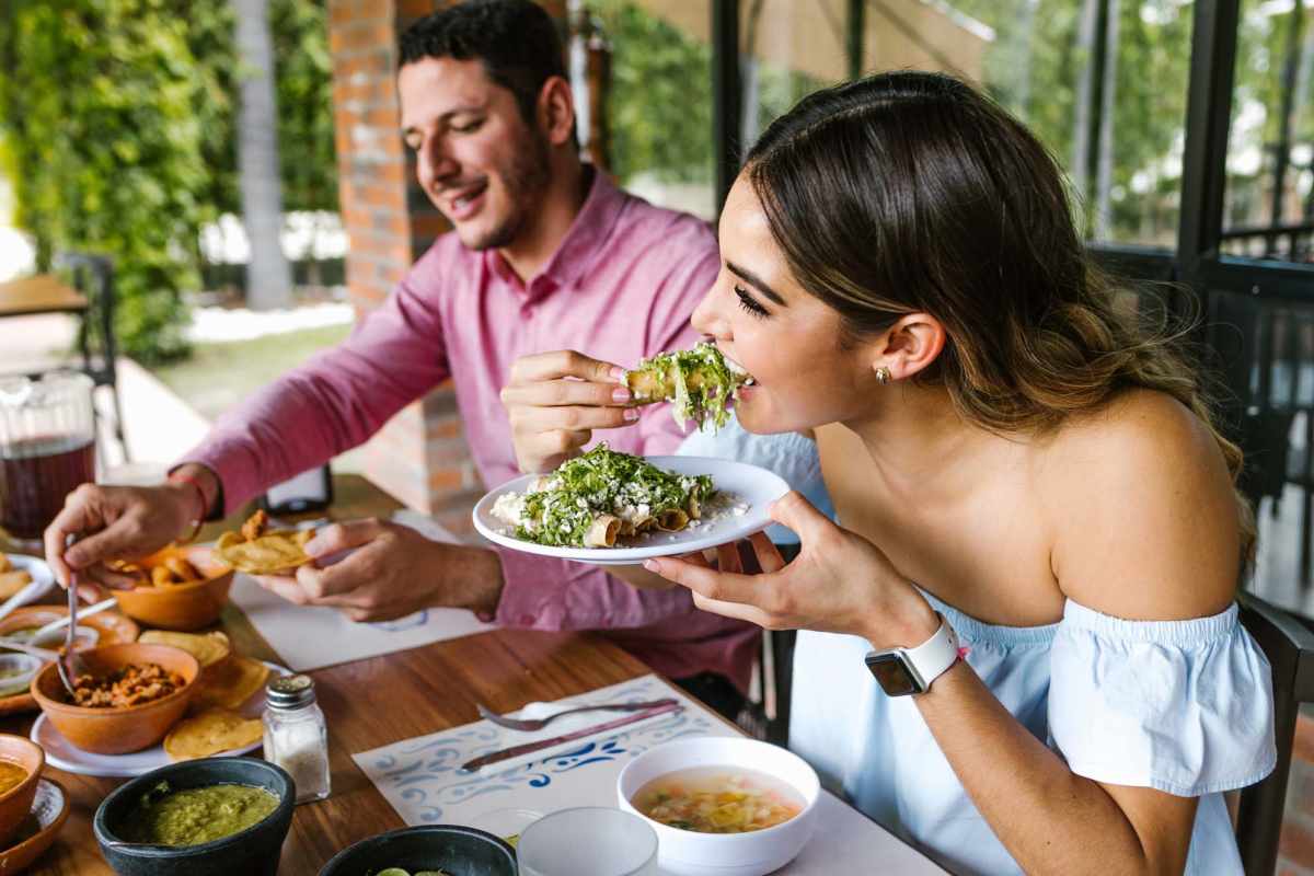 Couple enjoying a meal at a table filled with various dishes and drinks at Willowbrook I in Lafayette, Louisiana 