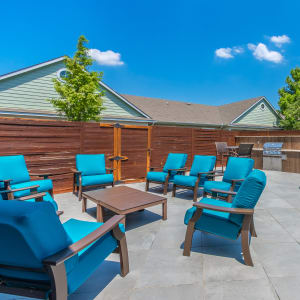 Lounging chairs outdoors on a sunny day next to a pool at Sunstone Village in Denton, Texas