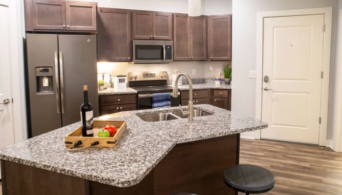 Modern appliances in a kitchen with granite countertops at Attivo Trail Waukee in Waukee, Iowa