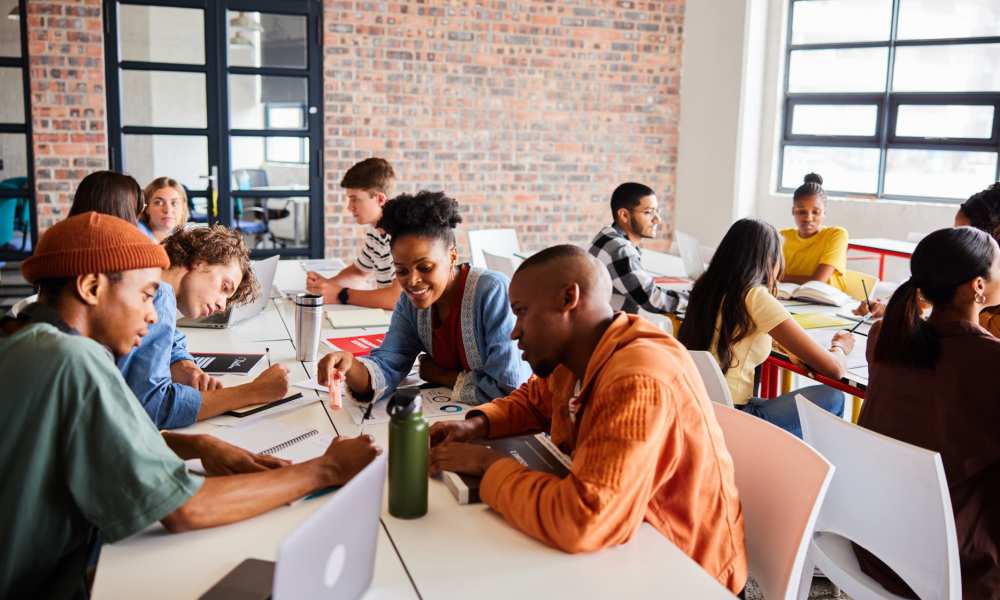 A group of students sitting at tables, focused on their work and interacting with one another at Midtown 905 in Denton, Texas