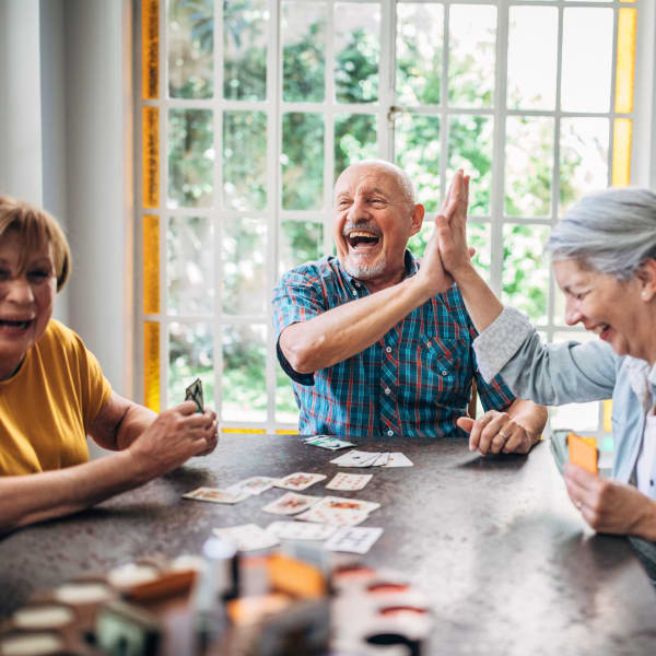 Group of residents playing a card game at The Woodmark at Daytona Beach in Daytona Beach, Florida