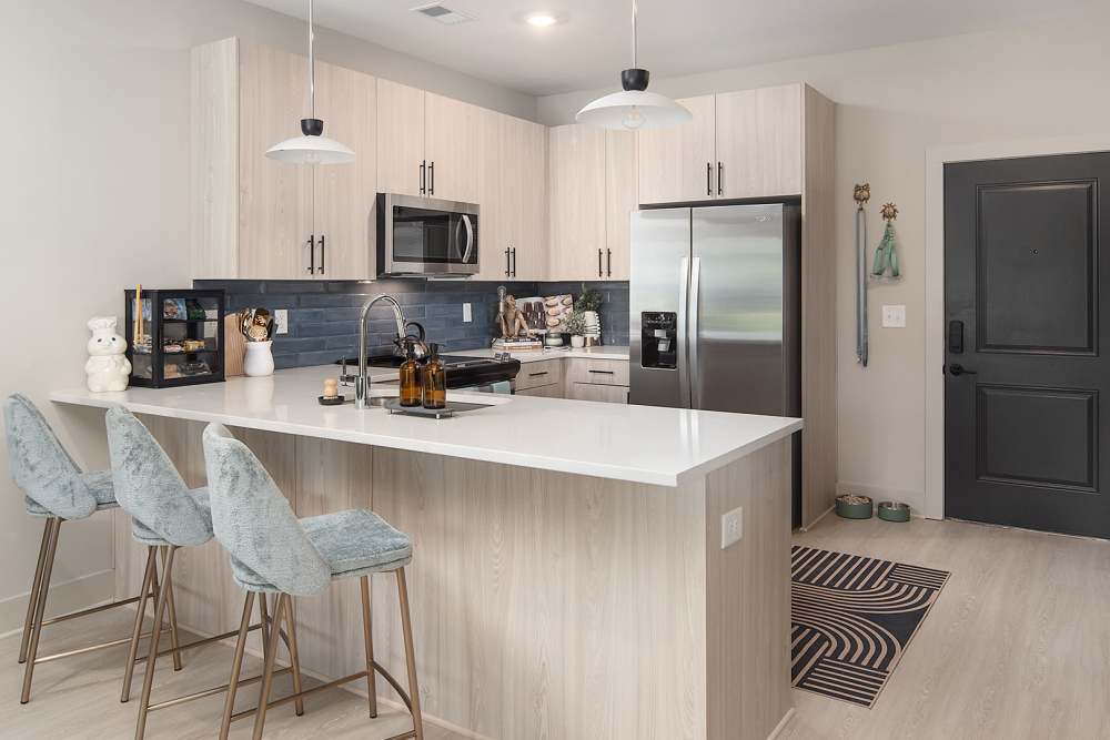 Open-concept kitchen with pendant lights and stainless steel appliances at Cypress Point Luxury Apartments in Mooresville North Carolina