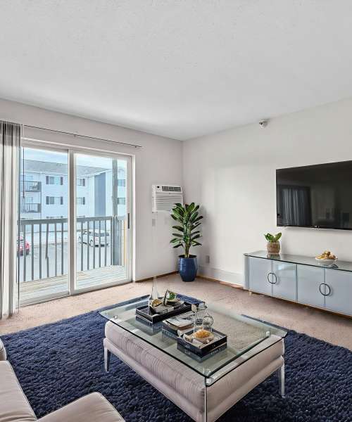 Spacious living room with attached balcony at Valley View Apartments in Cedar Rapids, Iowa